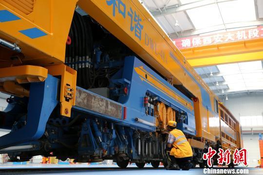 圖為工人正在清理大型養路機械?！堖h 攝